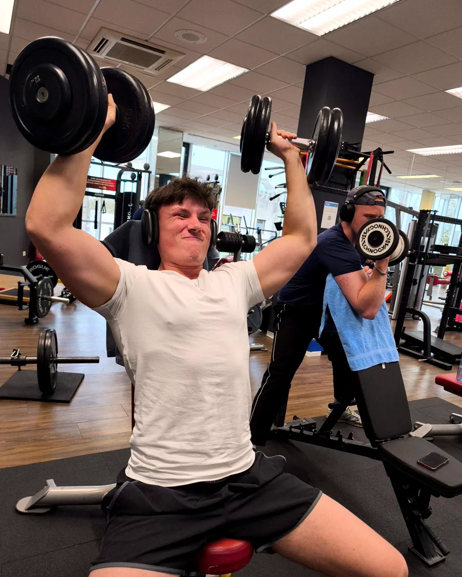 Mitglied beim Schulterdrücken mit Kurzhanteln im FIT-UP Sportcenter